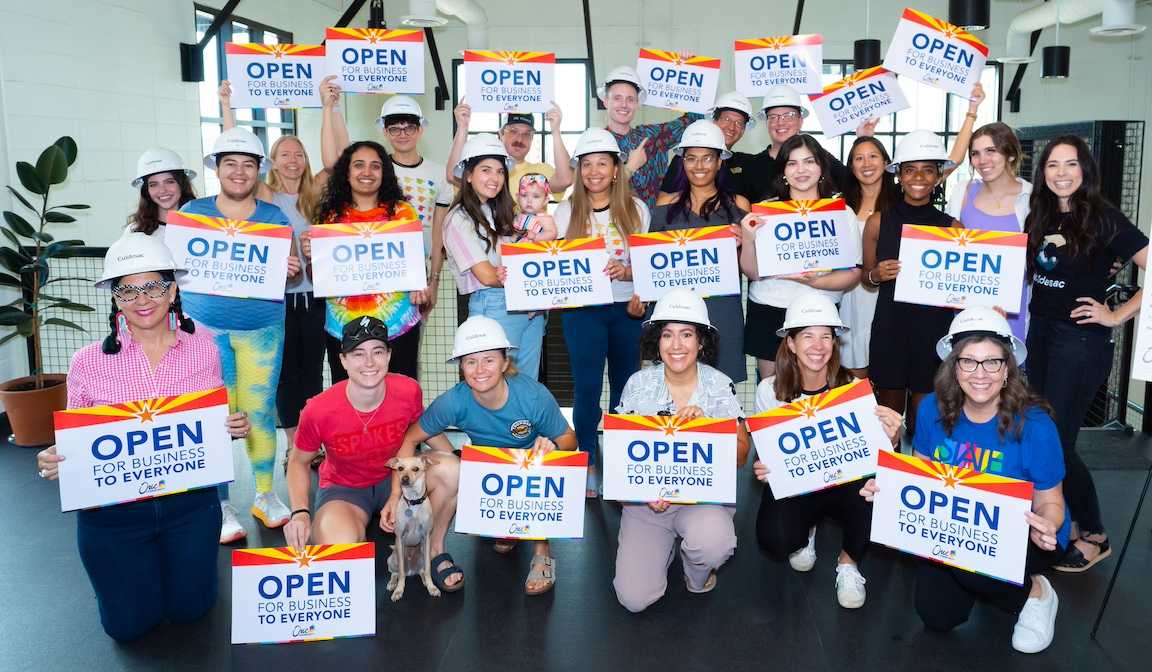 People holding signs saying "Open for business to everyone" at Culdesac's signing of the Unity Pledge