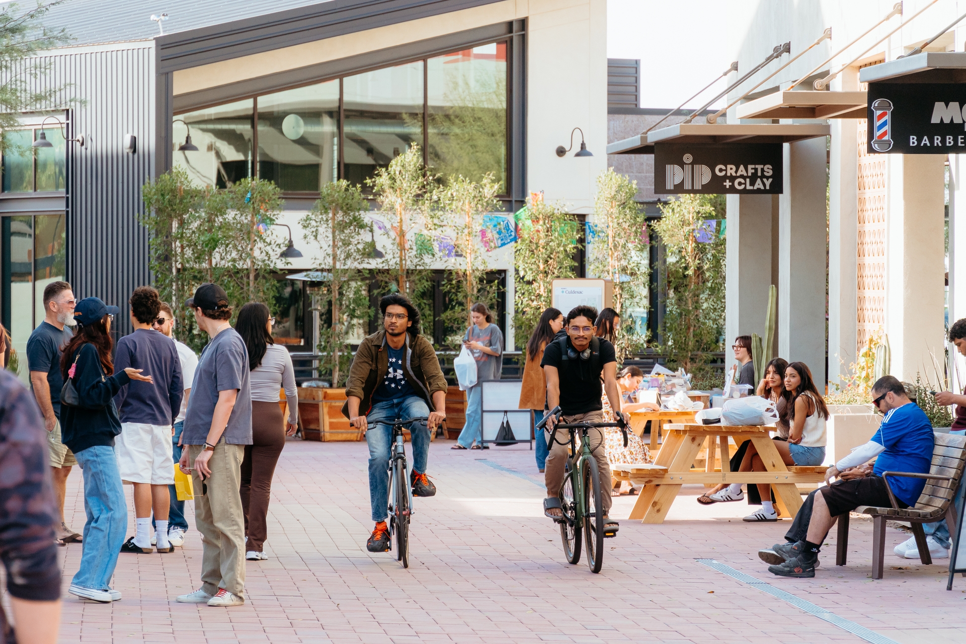 Residents biking through the plaza past local shops